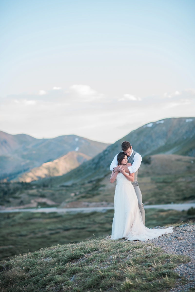 Loveland Pass Sunset Glow Bride and Groom hold each other 