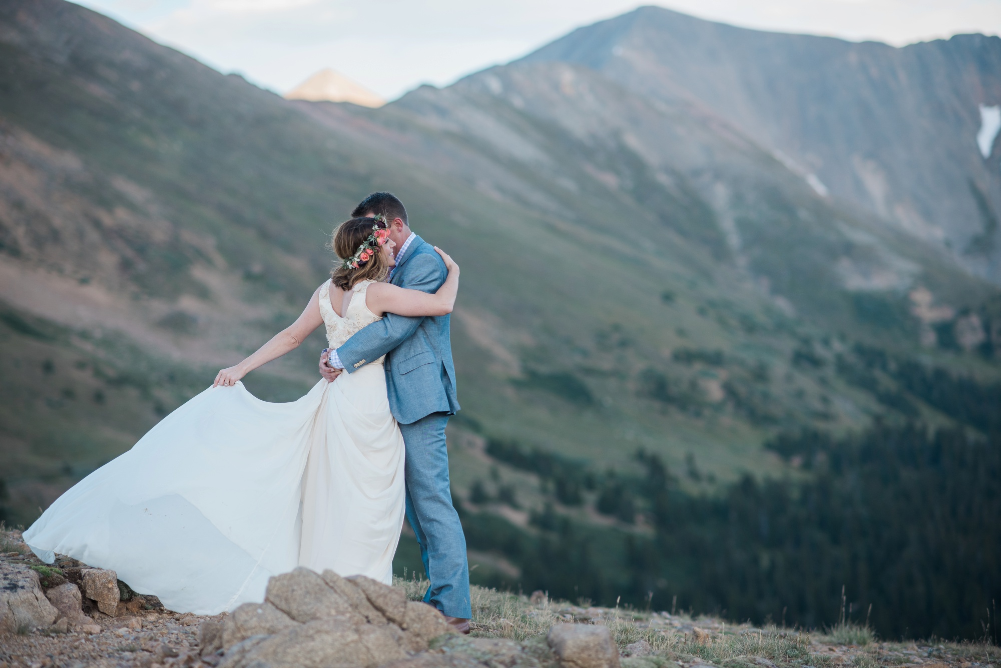 Holding one another on a mountain top after their intimate wedding on Loveland Pass Colorado with Jenna Wren Photography