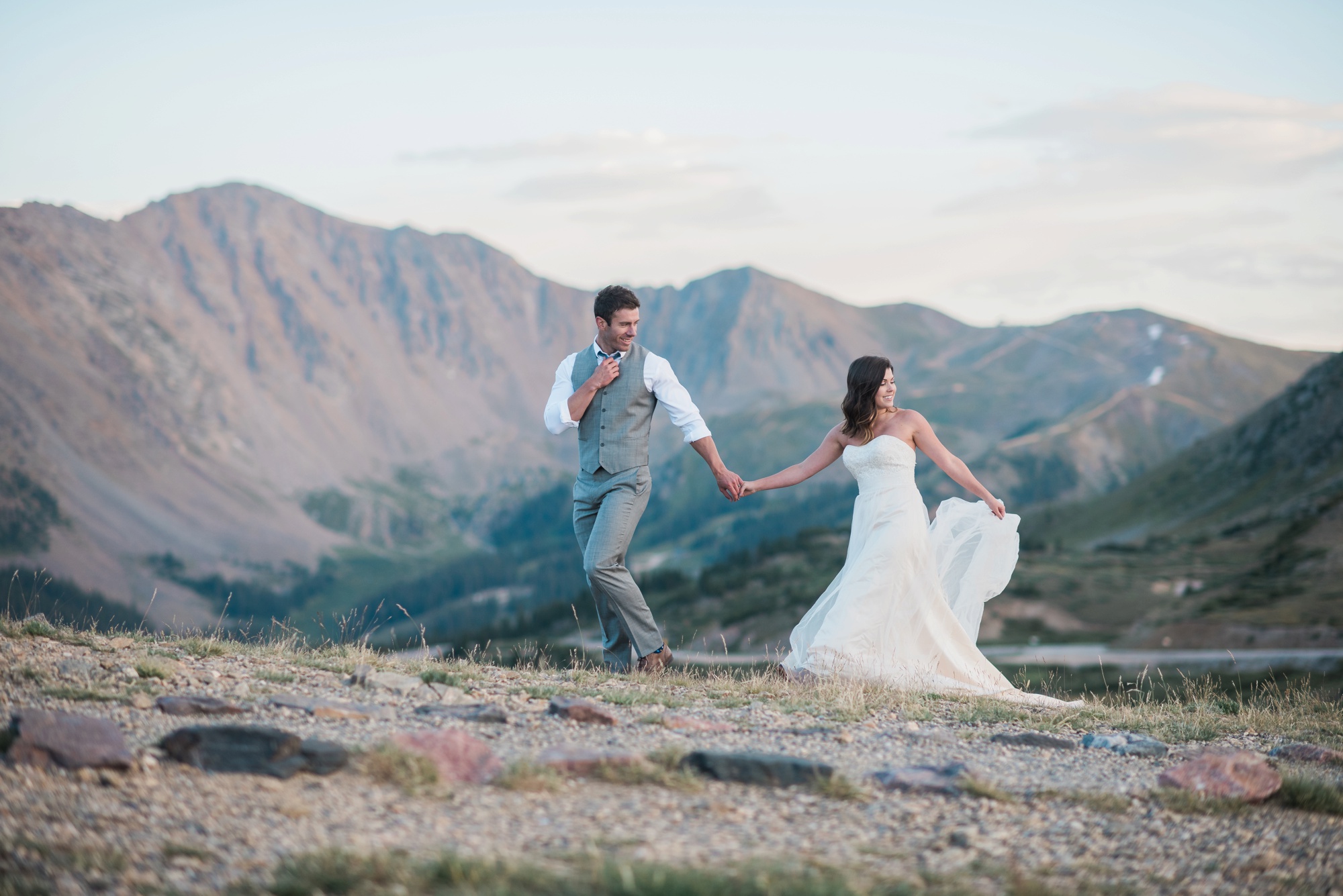Walking along a ridge line among Colorado Rocky Mountains after their wedding 