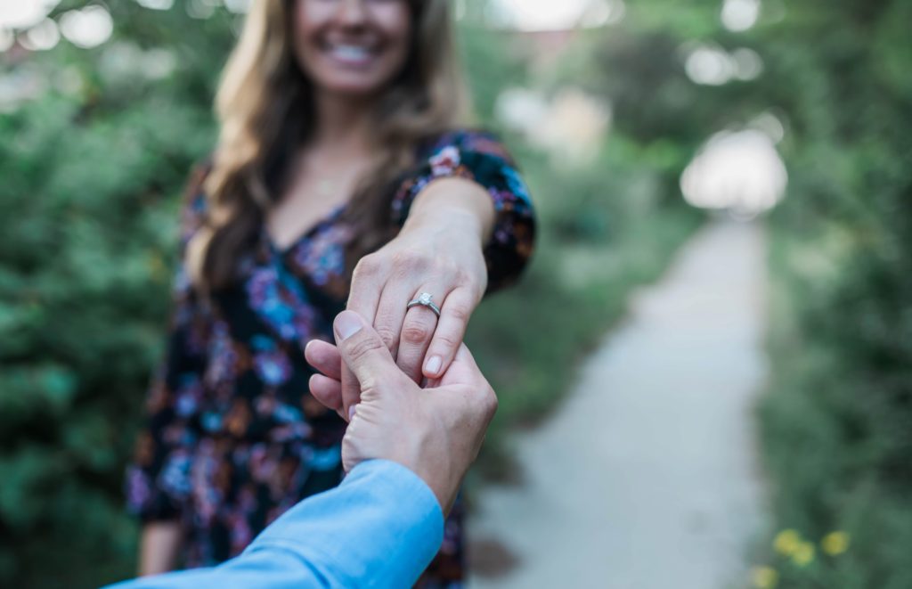 Holding hands to show off her engagement ring in a detailed photo with Norfolk Virginia Fine Art Wedding Photographer Jenna Wren 
