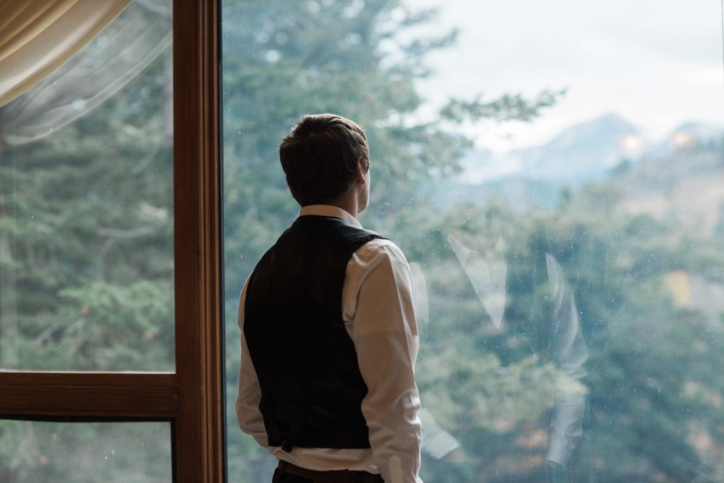 Groom portrait with view of Rocky Mountains National Park in Estes Park, Colorado getting ready portrait