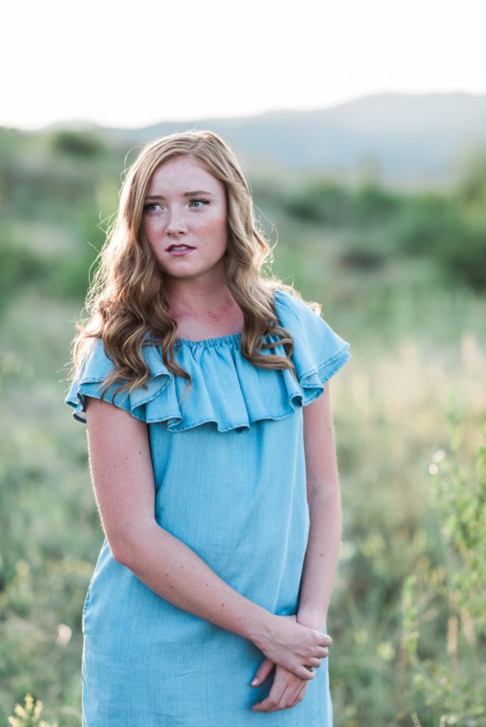 warm backlit senior girl in a blue denim dress