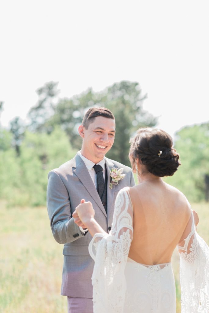 Groom smiles at his bride during first look 