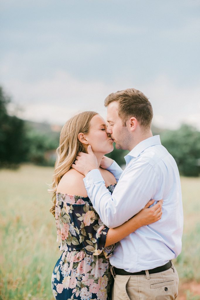 Couple kiss with Garden of Gods in the background during their portrait session 