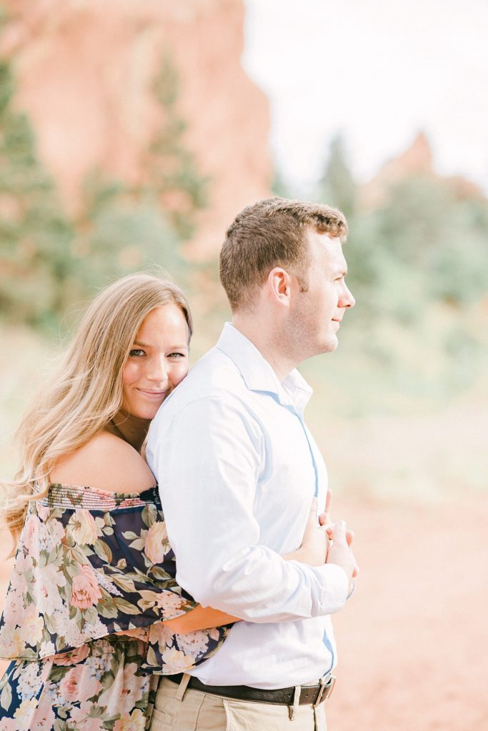 Couple hug at Red Rock Open Space in Colorado Springs during their 10th anniversary portrait session  