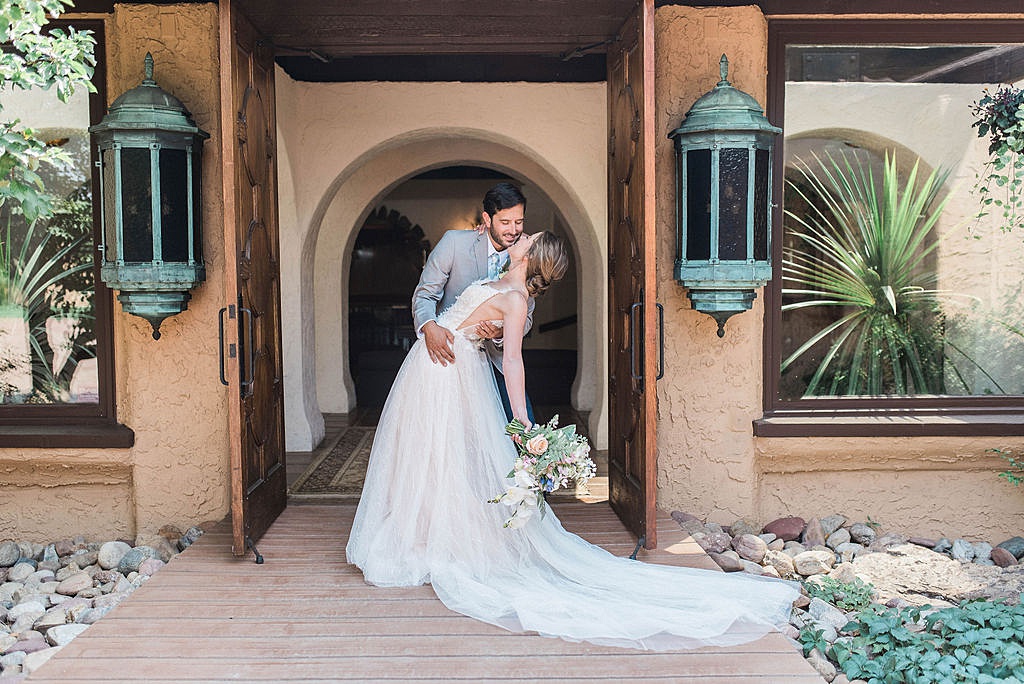 beautiful entrance to Villa Parker with couple kissing during summer wedding