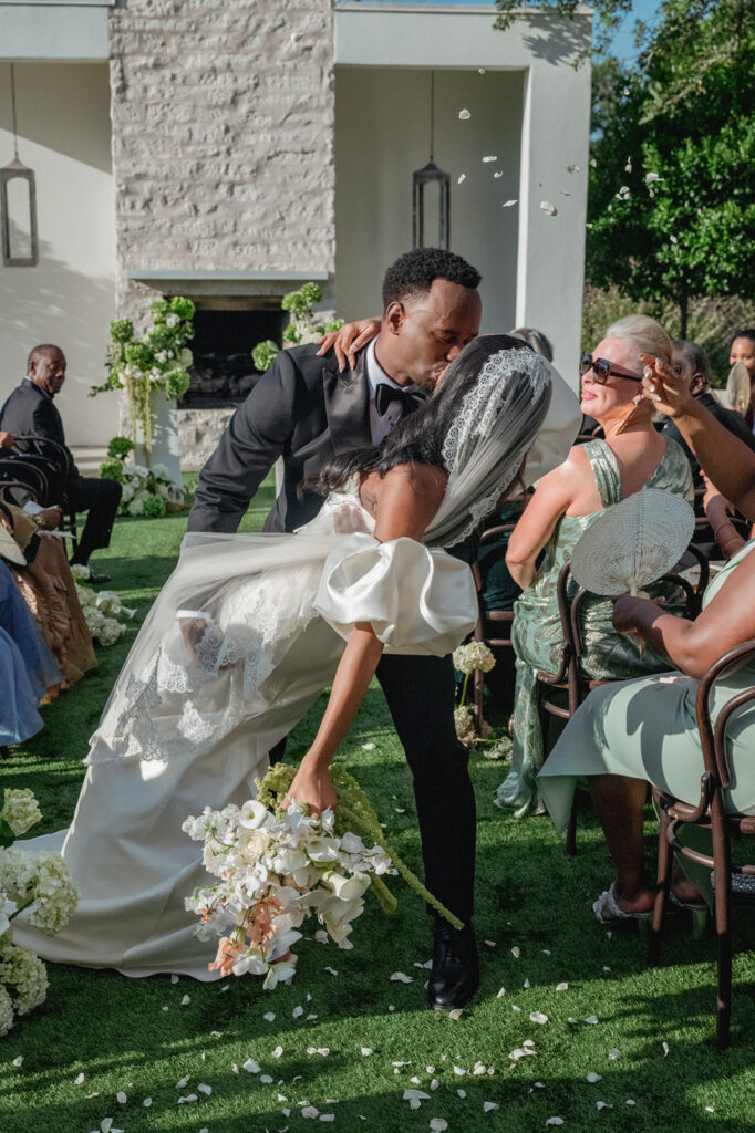 couple kiss down the aisle at The Arlo in Austin known as the premier elegant wedding venue