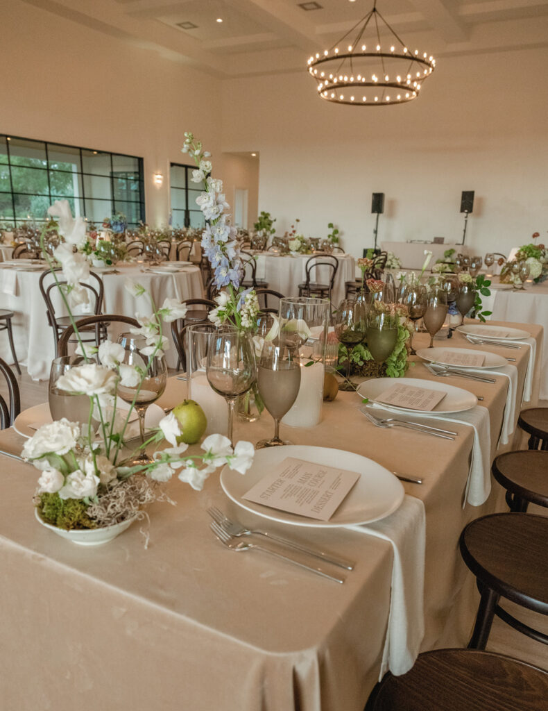 Timeless reception tablescape with minimalist white florals, candlelight, and modern place settings at The Arlo wedding venue.