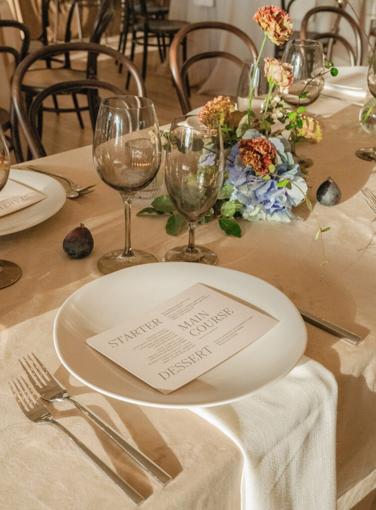 Timeless reception tablescape with minimalist white florals, candlelight, and modern place settings at The Arlo wedding venue.