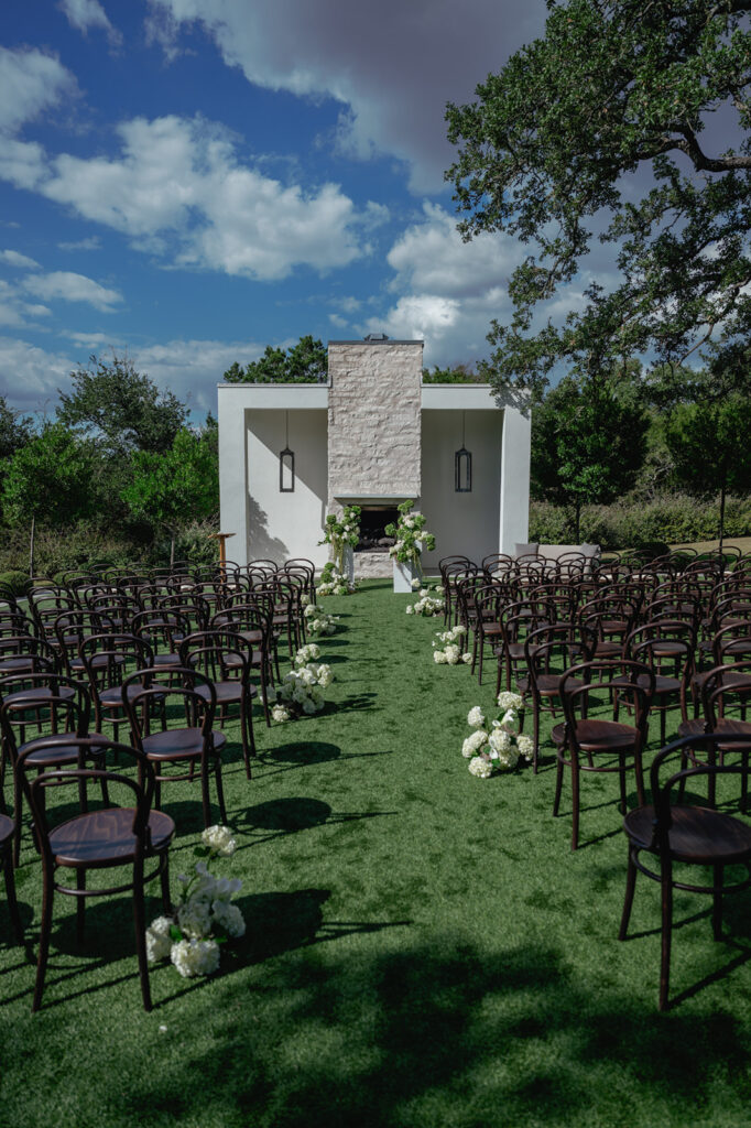 Outdoor wedding ceremony at The Arlo with modern black-and-white design and sleek floral aisle arrangements.